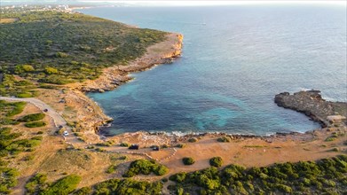 Aerial view of a rocky coastline with blue sea and green vegetated areas