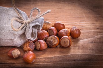 Hazelnuts and sack on vintage wooden board Food and drink concept
