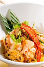 Fresh seafood thai style salad with glass noodles on a bowl close up