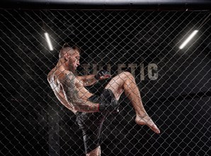 Professional kickboxing fighter trains in a cage ring. The concept of sports