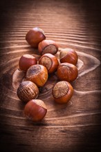 Small pile of hazelnuts on vintage board Food and drink concept