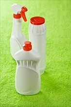 Three plastic bottles on a green background