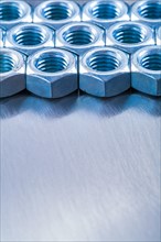 Copy space image of stainless steel nuts on metallic background construction concept