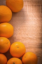 Frame of orange fruits on wooden board with organised copyspace