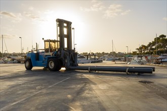 Forklift lowers a boat into the water at a marina