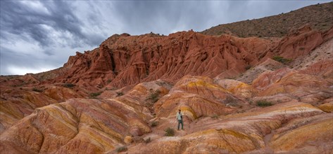 Tourist hikes through canyon of eroded sandstone formations