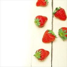 Fresh organic strawberry over white rustic wood table