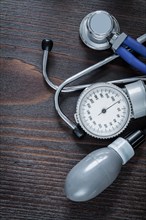 Medical stethoscope and blood pressure monitor on vintage wooden background medicine concept
