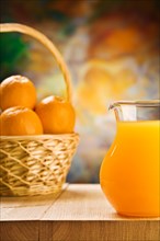 Jug of orange juice and oranges in a bucket