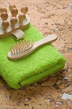 Massager and hairbrush on a green towel