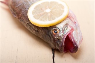 Fresh whole raw fish on a wooden table ready to cook