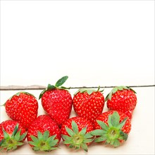 Fresh organic strawberry over white rustic wood table