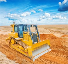 Bulldozer on sand in the field