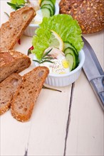 Fresh organic garlic cheese dip salad on a rustic table with bread
