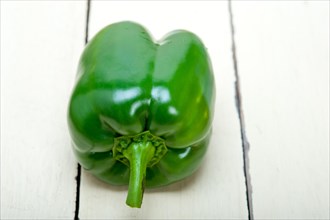 Green fresh bell pepper over old wood table