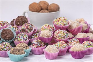 A selection of handmade light and dark rum balls on a white background