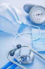 Masks stethoscope blood pressure monitor on blue background medical concept