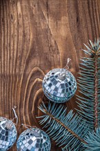 Christmas mirror disco balls and Christmas tree branch on old wooden board with copy surface vertical version