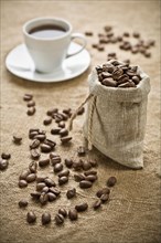 Coffee beans and a cup of coffee on a bag