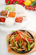 Original fajita sizzling smoking hot served on iron plate and fresh vegetables on background
