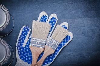 Composition of paint brushes cans protective gloves on wooden board