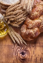 Composition bread bottle oil wheat ears flour in bucket on vintage wooden board food and drink concept