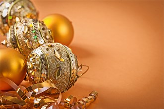 Composition of golden Christmas baubles on a light brown background