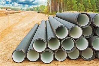 Stack of large water pipes on a construction site