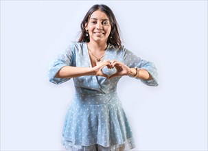 Funny young girl making heart shape with hands. Teen girl making heart shape with her hands. Happy girl making heart shape with hands isolated