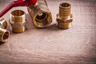 Plumbing tools Brass pipe connector on wooden board Close Up