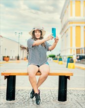 Lifestyle of tourist woman sitting taking selfie in the cathedral of Granada. Young travel woman sitting taking a selfie outdoors