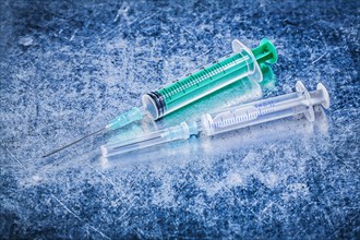 Medical disposable needle syringes on metallic background medicine concept
