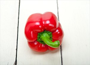 Red fresh bell pepper over old wood table