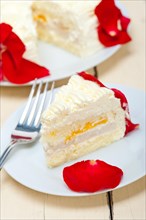 Whipped cream mango cake with red rose petals