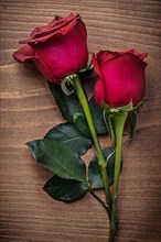 Fragrant red rosebuds on wooden board holiday concept