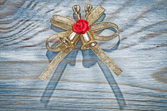 Golden Christmas knot with bell on wooden board holidays concept