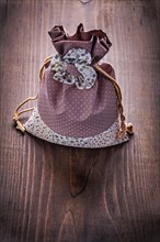 Beautiful fabric bag with strings on vintage wooden board