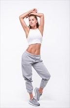 Young white fitness woman wearing sportswear standing over white wall background. Fitness concept. Mixed media