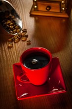 Coffee in a red cup on a wooden board