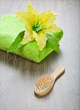 Yellow flower on towel with hairbrush