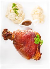 Original German BBQ pork knuckle served with mashed potatoes and sauerkraut isolated on white