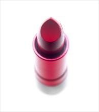 Vivid red lipstick tube over white background
