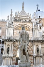 Figure on the giant staircase in the courtyard of the Doge's Palace with St Mark's Basilica