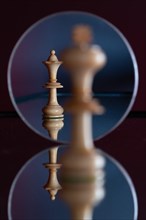 A queen chess piece can be seen in a mirror