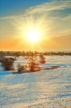 Sunset on a snow-covered field in winter