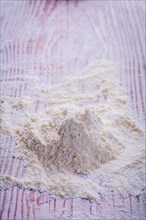 Spall pile of white natural flour on vintage wooden board food and drink concept