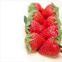 Fresh organic strawberry over white rustic wood table