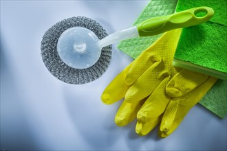 Cleaning metallic brush washcloth sponge safety gloves on white surface