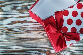 Red gift box with bow on vintage wooden board