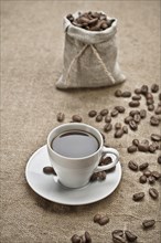 Coffee grains and a cup of coffee on a bag